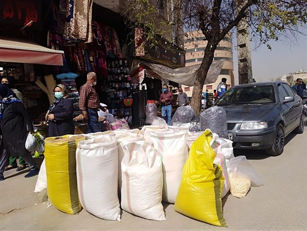 فرد مغازه‌دار شیرازی آجیل‌های غیرقابل مصرف خود را در خیابان ریخته است