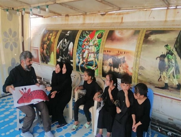 مربی تنگستانی در مسیر پیاده روی اربعین خدمت فرهنگی می‌کند